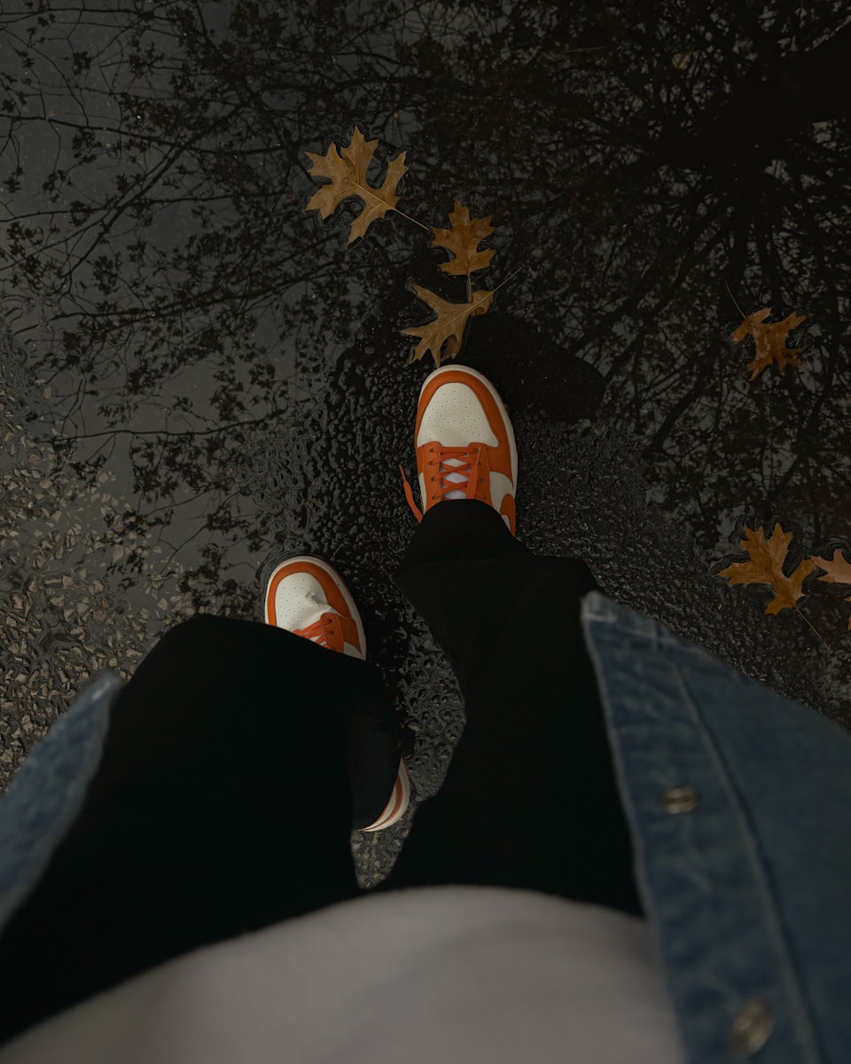 A person standing on a sidewalk with their feet up