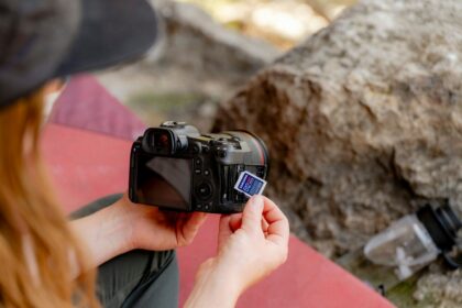 A woman taking a picture of a rock with a camera