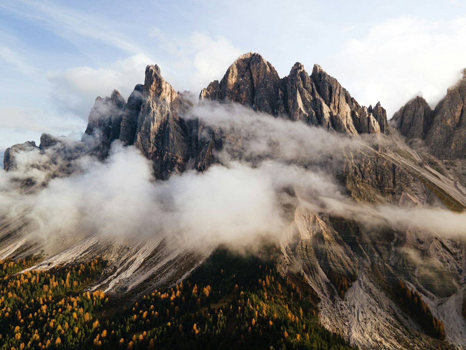 A mountain range covered in clouds and trees